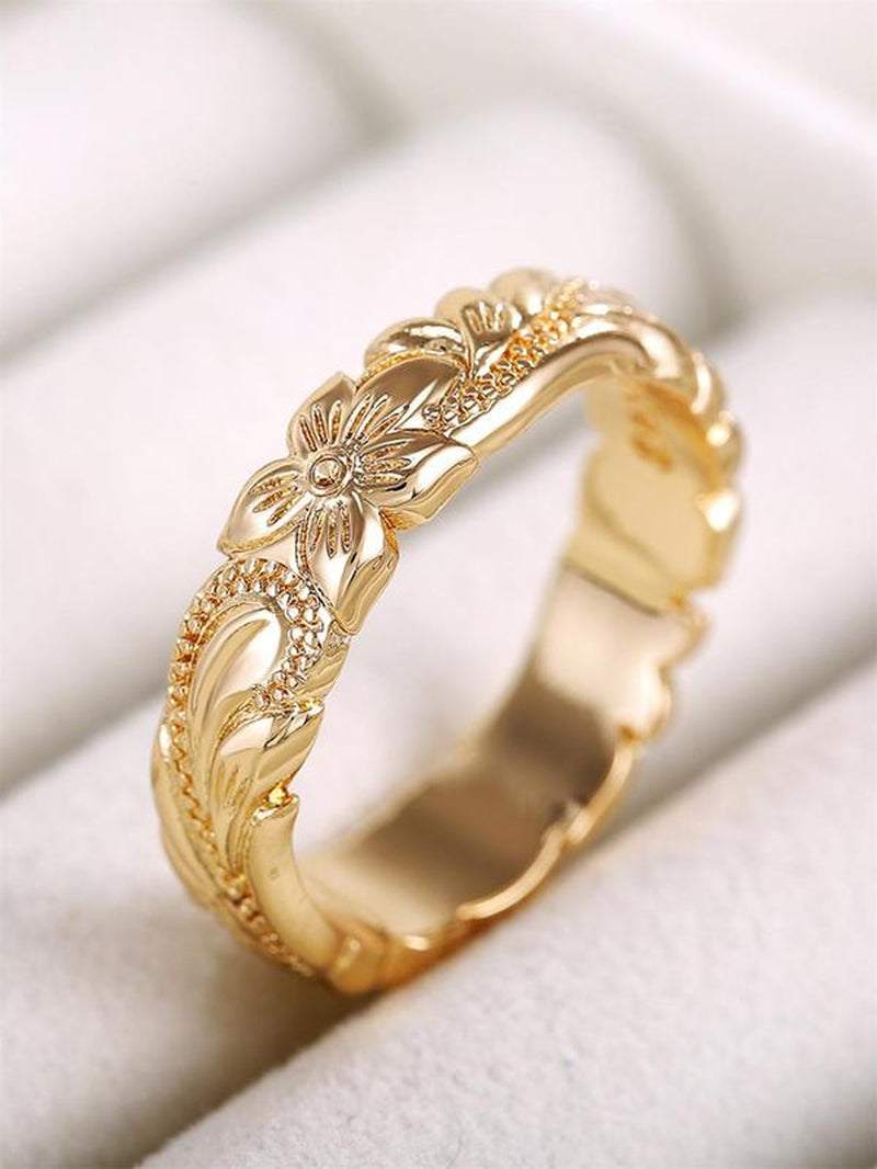 Close-up of a delicate engraved flower ring with detailed floral patterns for women
